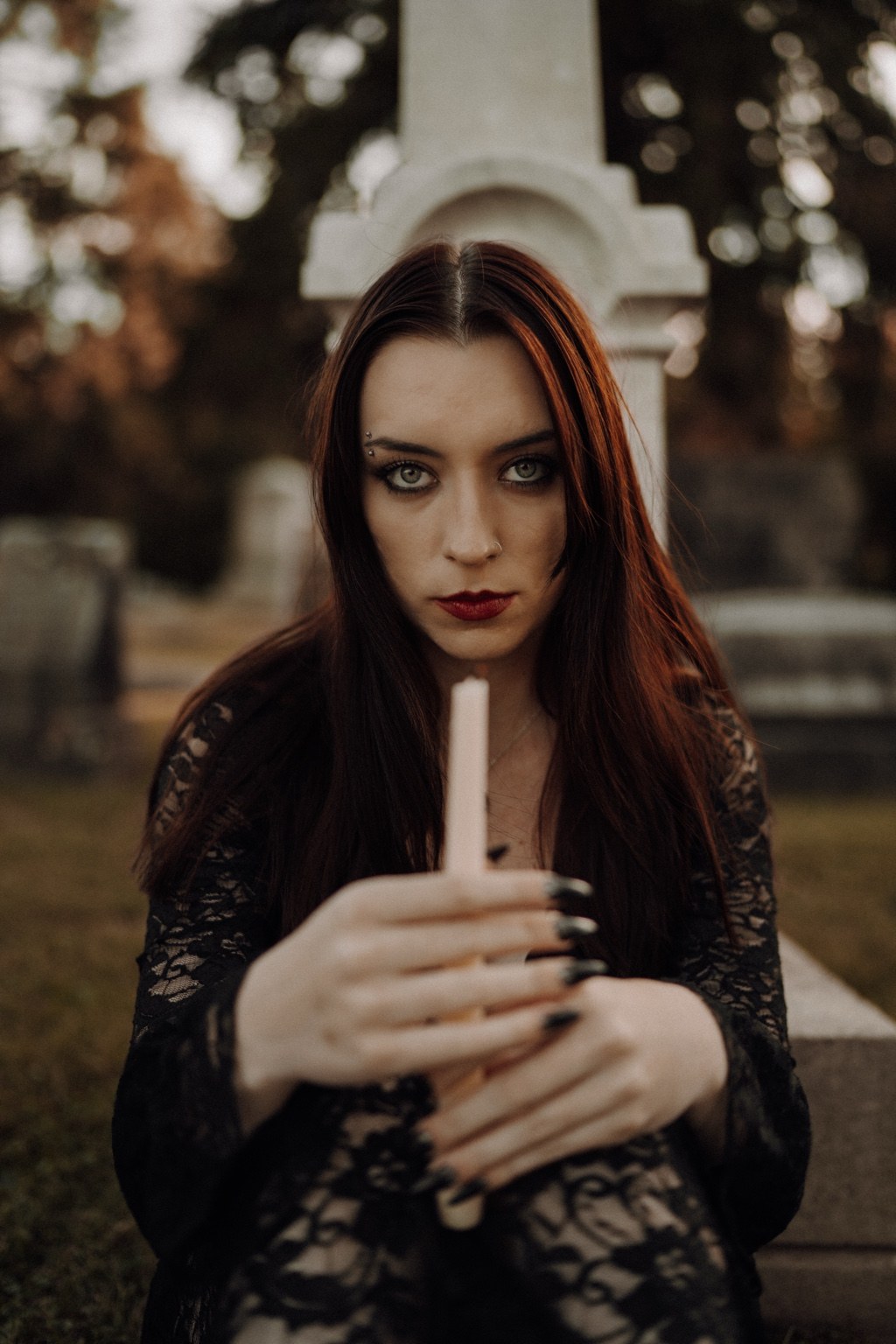 Moody portrait of a woman in black holding a candle