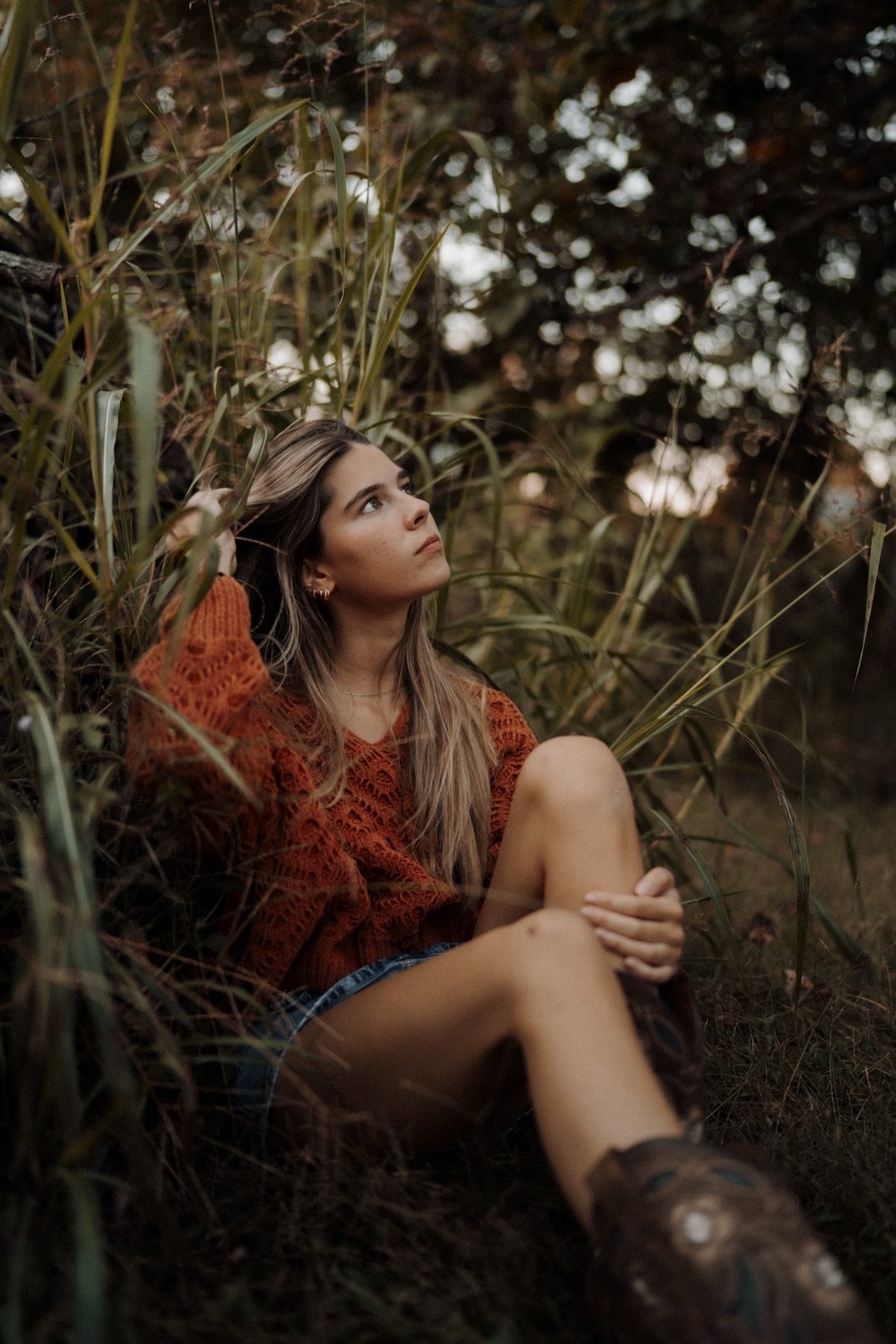Outdoor portrait in a rust sweater among autumn grasses